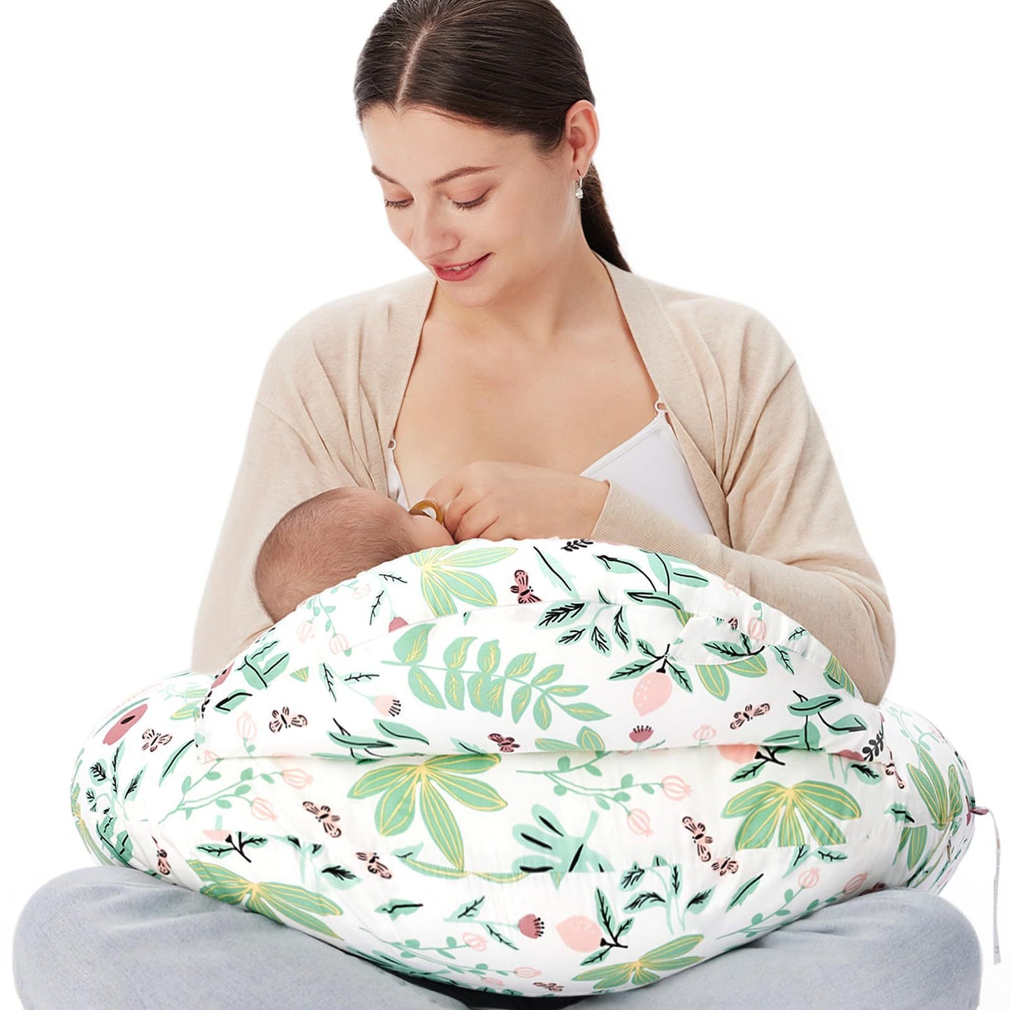 "Mother seated on the floor using a multifunctional nursing pillow to comfortably cradle her baby for breastfeeding support."