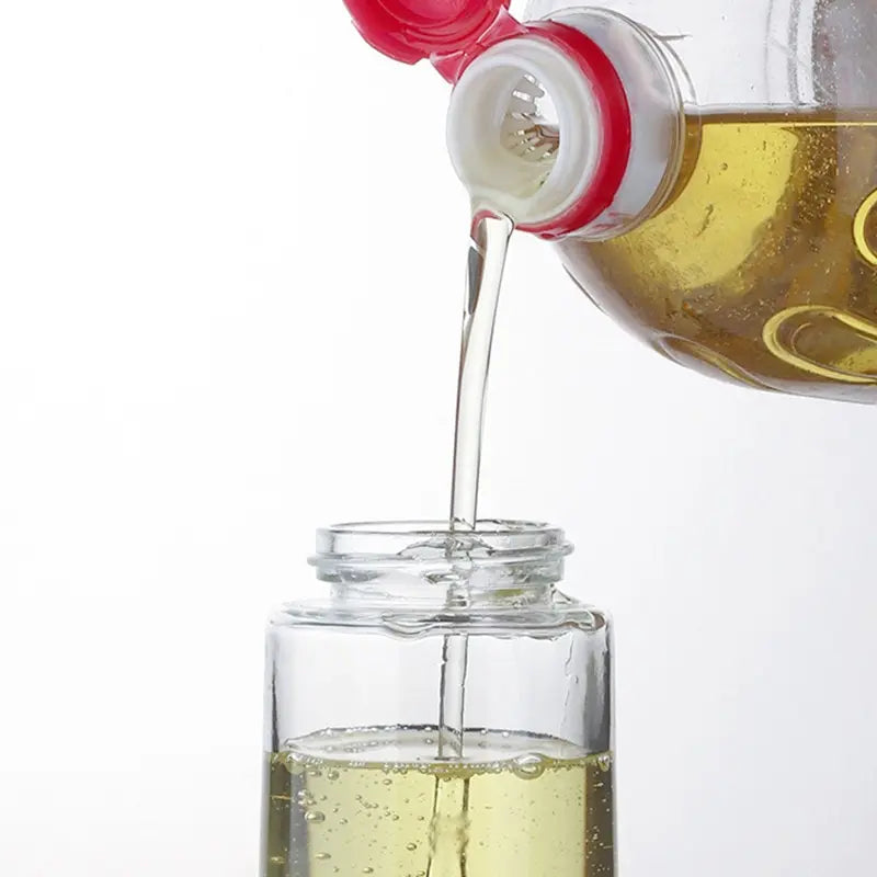 "Bottle pouring clear liquid into a glass jar, captured against a clean white background, illustrating precise pouring or ingredient transfer."