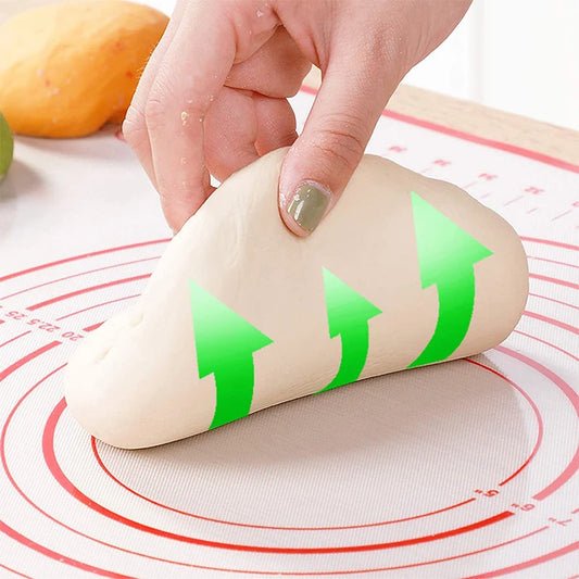 Rolling pin with green floral designs placed on a non-stick baking mat for dough preparation