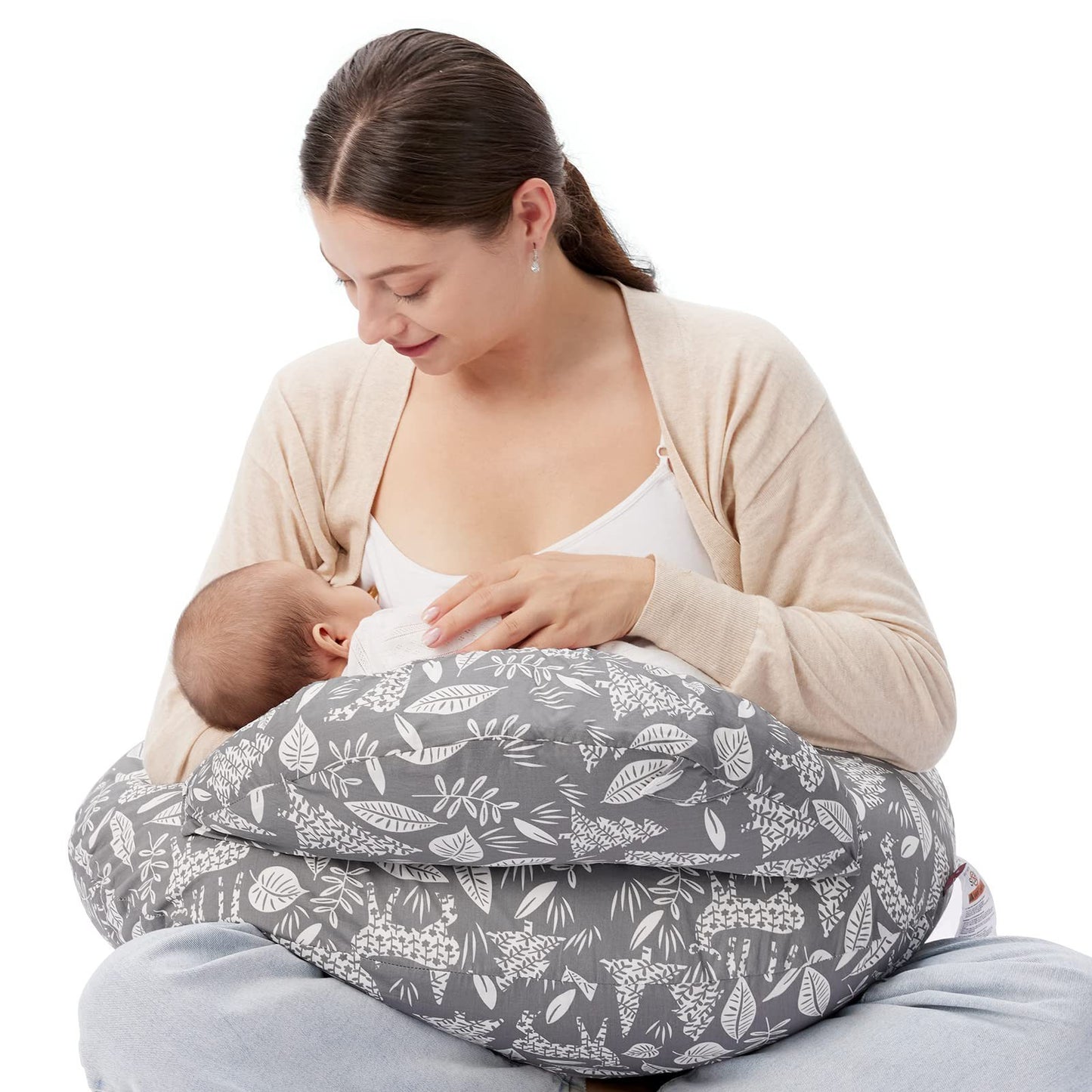 
"Mother sitting on the floor using a multifunctional nursing pillow to comfortably support her baby during breastfeeding."