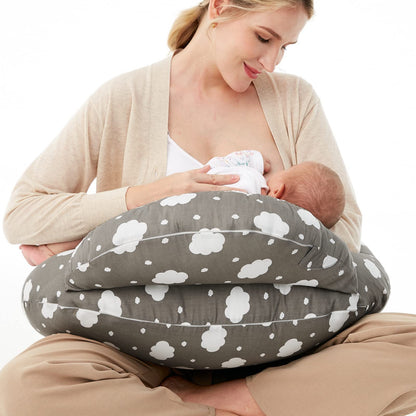 
"Mother sitting on the floor using a multifunctional nursing pillow to comfortably support her baby during breastfeeding."