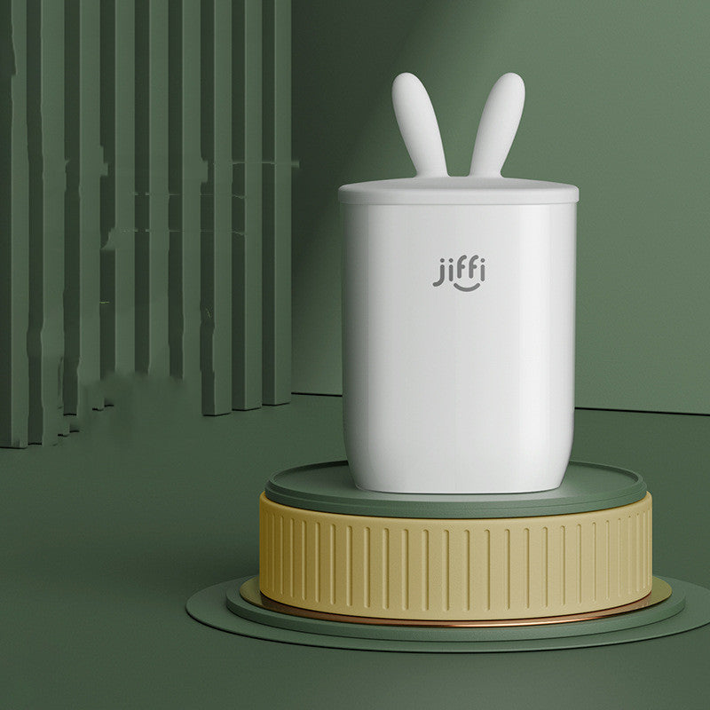 
"White container with rabbit ears placed on a green platform against a matching green background, ideal for baby snacks or decorative storage."