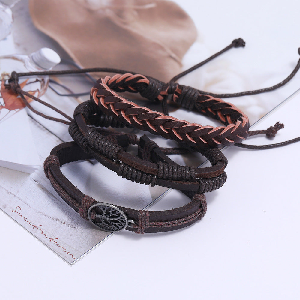 
Set of braided leather bracelets with central Tree of Life charm displayed on a textured surface – unisex spiritual jewelry