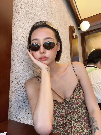 Woman wearing retro oval sunglasses – summer indoor fashion with floral dress