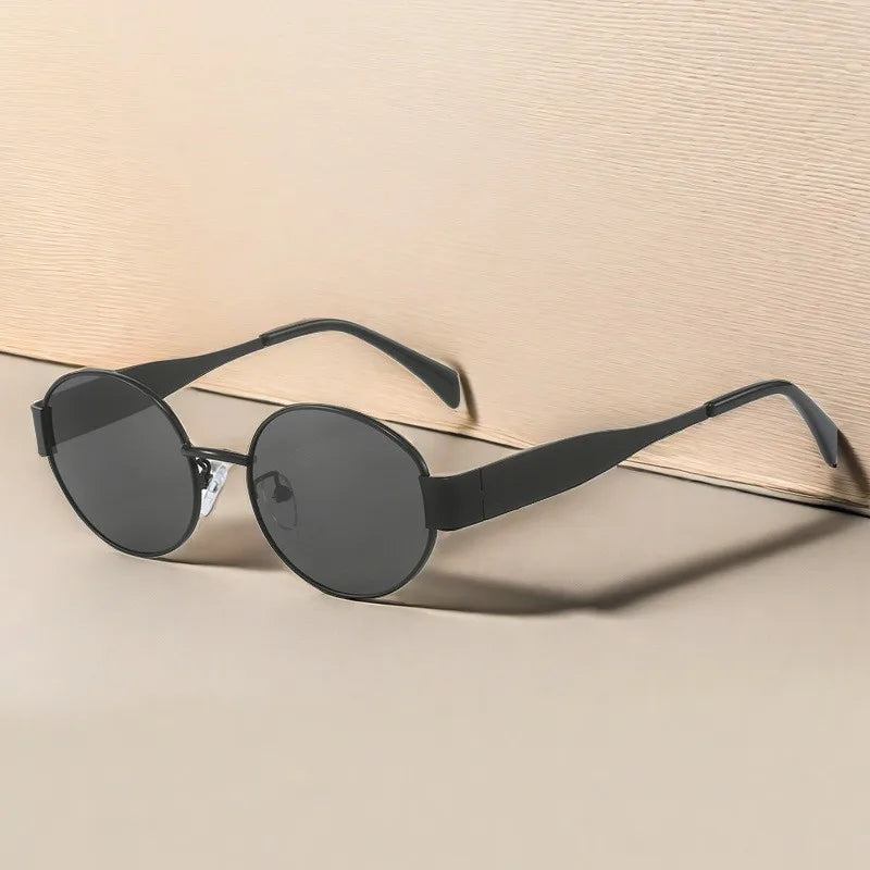 Classic black sunglasses with dark lenses – stylish flat-lay on beige background