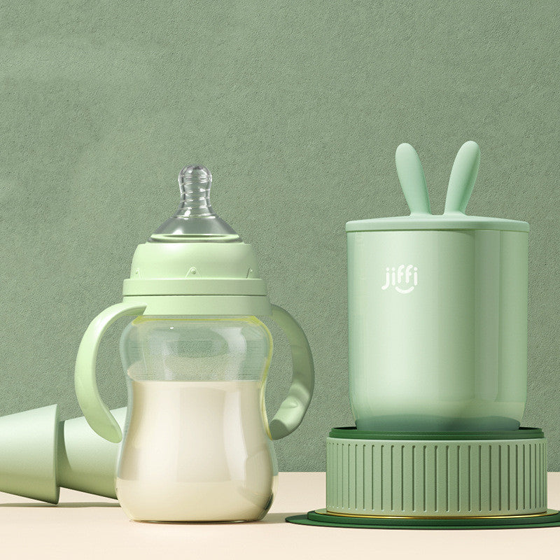 
"Green baby bottle and matching training cup set placed on a light green background, designed for infant feeding and transition."