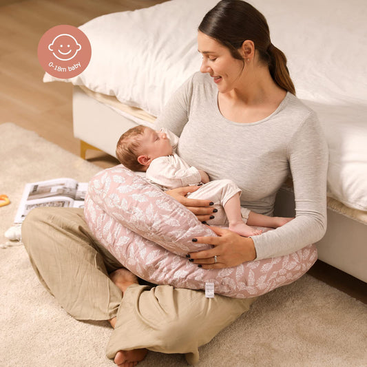 
"Mother sitting on the floor using a multifunctional nursing pillow to comfortably support her baby during breastfeeding."